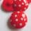 Red polyester button with white dots