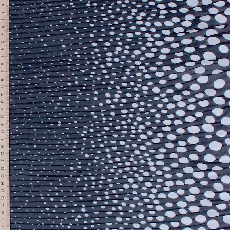 Gekreukelde sluierstof in polyester met witte bolletjes op een donkerblauwe achtergrond
