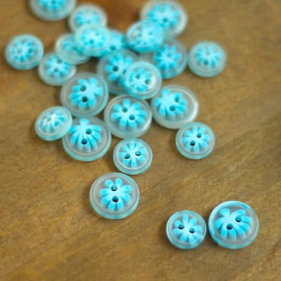Transparent resin button with blue floral pattern