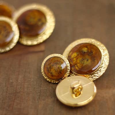 Button with metal and amber aspect