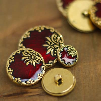Round resin button with golden metal and enamelled red