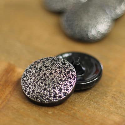 Button with hammerd metal aspect