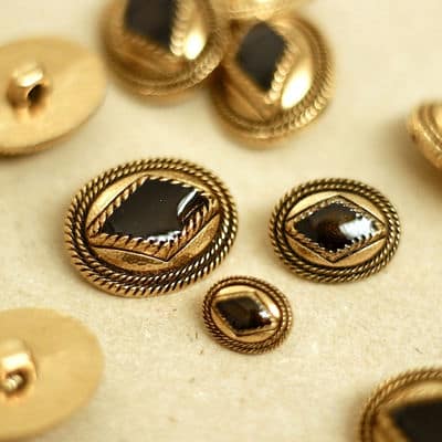 Button with golden metal and black aspect