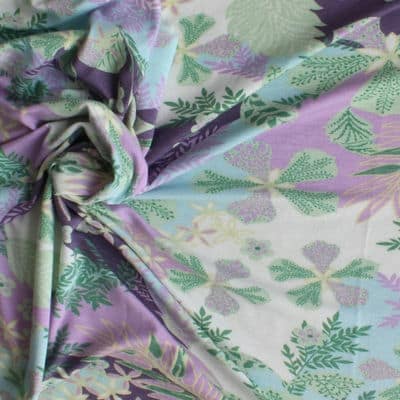 Jersey stof met paarse en groene bloemen op witte achtergrond