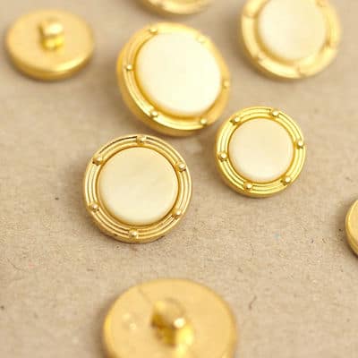 Button with golden metal aspect and off-white