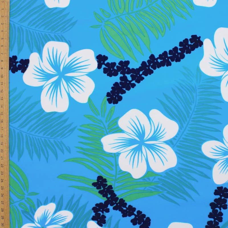 Lycra fabric with green, white and blue flowers on blue background