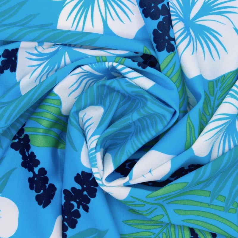 Tissu en lycra à motifs fleurs vertes, blanches et bleues sur fond bleu